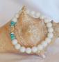 Un joli bracelet très féminin où la perle-charme, de Cristal de roche, est gravée du Mantra Universel. Éclairée par les deux perles à décor de brillants. Raffiné, gracieux, la couleur joyeuse les petites perles turquoise apporte sa fraîcheur à l'ensemble.