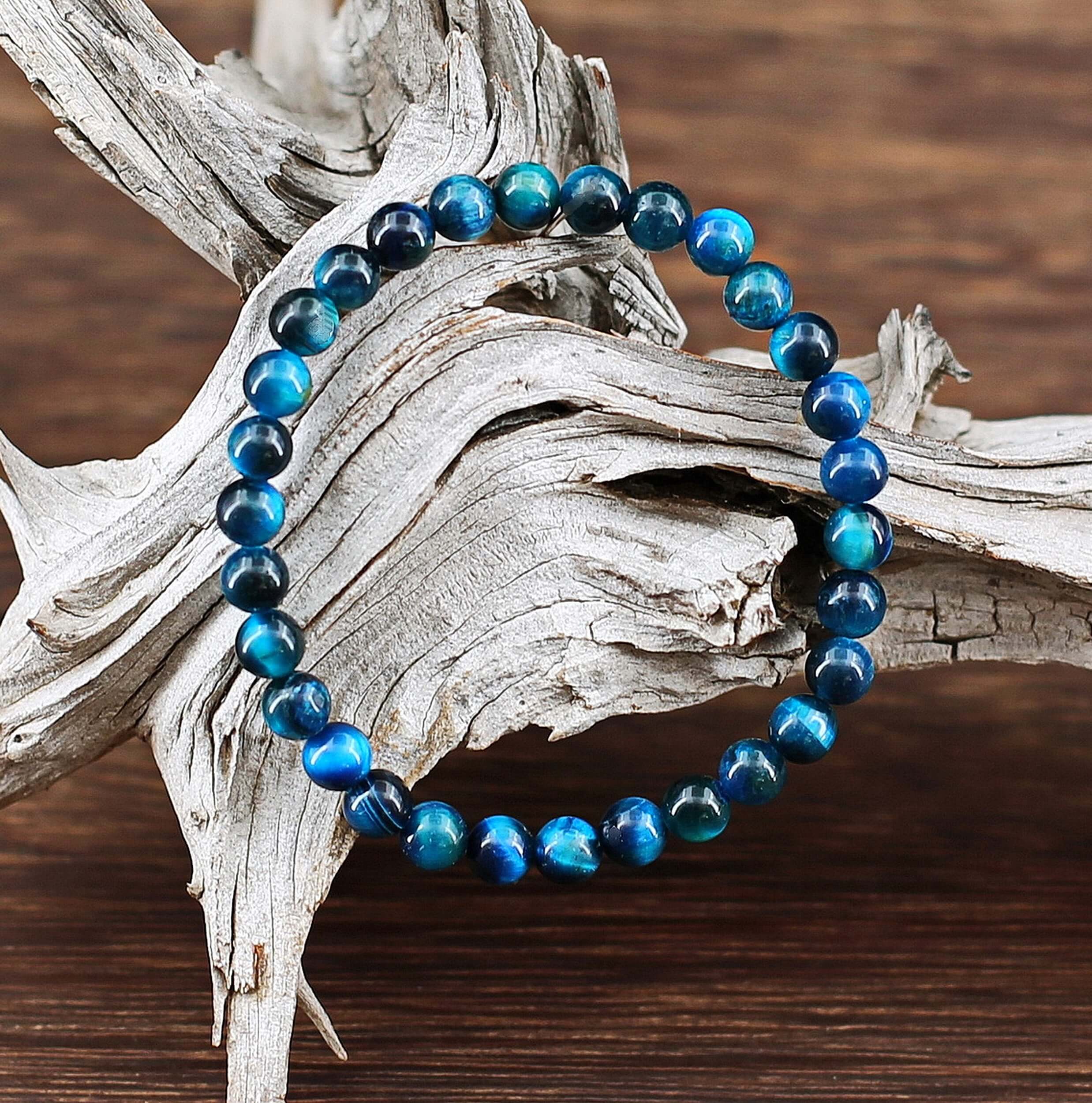 Ce fin bracelet composé de perles de pierre Oeil de tigre colorées de couleur queue de Paon, couleur au fort symbole de guérison, dans la tradition du Bouddhisme Tibétain.