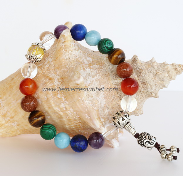 Riche bracelet-mala dédié aux sept chakras: deux séries de perles de pierres spécifiques séparées par deux ensembles de perles de Cristal de roche, l'un orné d'une perle gravée du Mantra Universel OM, et à l'opposé, d'une perle de tête typique du mala tib