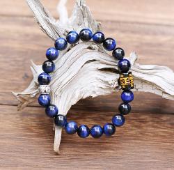 Sobriété, efficacité, pour ce magnifique bracelet de perles de pierre Oeil de tigre couleur bleu outremer moiré du plus bel effet. Orné d'une perle cylindrique de cuivre argenté et d'un cylindre en Onyx gravé