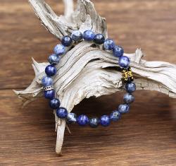 Bracelet porte-chance Sodalite, élégant et précieux, ce bracelet raffiné s'inscrit dans la tradition des bracelets de protection tibétains, orné d'une perle cylindrique de cuivre argenté et d'un cylindre en Onyx gravé comme moulin à prière gravé du Mantra