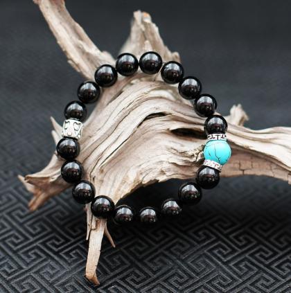 L'assemblage Onyx, perles plates de métal argenté aux motifs finement gravés, vient soutenir une très belle Turquoise traitée taillée en perle baroque. Un ensemble typiquement masculin, raffiné.