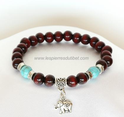 Joli bracelet ​​​d'inspiration ethnique créé par mes soins. Composé de perles de bois de rose, sa magnifique couleur rouge profond symbolise dans le bouddhisme tibétain