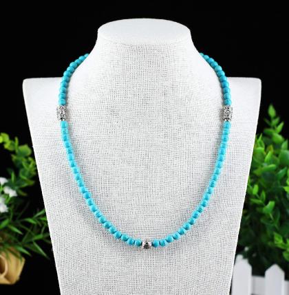 Un fini impeccable pour ce joli collier de perles de Turquoise traitée. Orné de deux cylindre votif de métal argenté gravé du Mantra Universel porte-bonheur et d'une perle motif ethnique à l'opposé. Dégage une belle énergie positive.