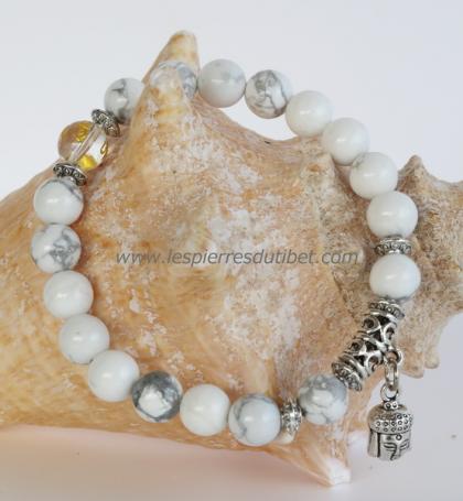 Une délicate harmonie de gris, de reflets argentés, de blancs tendres pour ce ravissant bracelet-mala, une perle de Cristal de roche gravée à l'or de la bénédiction OM MANI Universelle, orné de six perles ethniques traditionnelles et d'un pendentif-amulet