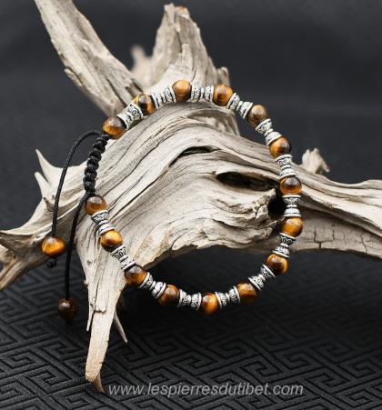 Joyeux bracelet ethnique de perles d'Oeil de Tigre alternées avec un choix de perles rituelles, double-coupe d'offrande. Belle association d'une pierre à la fois chatoyante et sensuelle, avec ces perles de métal argenté à la sculpture élégante. Un charm