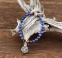 D'un bleu de cobalt doux et soutenu légèrement marbré, ce joli bracelet de perles de Sodalite est équilibré par quatre perles de pierre Oeil de tigre aux reflets d'or. Une perle-cylindre à prières et une médaille-talisman Arbre-de-Vie de métal argenté com