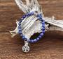 Fin bracelet de perles choisies de Sodalite qualité A+ garantissant une couleur soutenue assez exceptionnelle. Ce bracelet complète son action bénéfique par l'ajout de deux perles cylindriques aux motifs traditionnels sur deux pôles et l'ajout d'une médai
