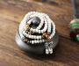 Ce précieux mala de perles d’ivoire végétal graines de Bodhi est ici composé comme un précieux bijou, les perles de pierre Oeil-de-Tigre apportant force et énergie, et le pendant orné d’un petit vajra de métal argenté, qui est le symbole le plus important