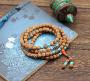 Ce fin mala de perles de graines Rudraksha montage classique du chapelet tibétain aux 108 perles porte les couleurs traditionnelles les bijoux tibétains. La couleur corail associée au bonheur, la couleur turquoise associée aux bienfaits;