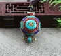 Joli Collier - Pendentif protection tibétain, couvercle orné d’émaux et pierres, réalisant un motif protecteur, représentant le Mantra OM bouddhiste, gage de la Paix Universelle et d'équilibre.