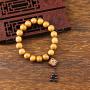 Ce bracelet-mala est composé de perles de bois d'Abélia brun-clair. Il est accompagné d'un pendant de bois de Santal rouge incrusté à l'or du logo traditionnel du Bonheur en talisman et terminé par six perlettes de Grenat: un bel ensemble pour un bracelet