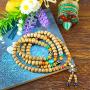 Mala composé de perles moyennes de bois d'Aloès et orné de perles couleur turquoise ambre tibétain traditionnelles, de deux perles magiques Dzi contre le mauvais sort pour le comptage dans la récitation des mantras. En perle-amulette: une interprétation m